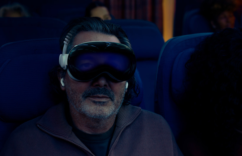 Person seated on an airplane wearing Apple Vision Pro with the Dual Knit Band